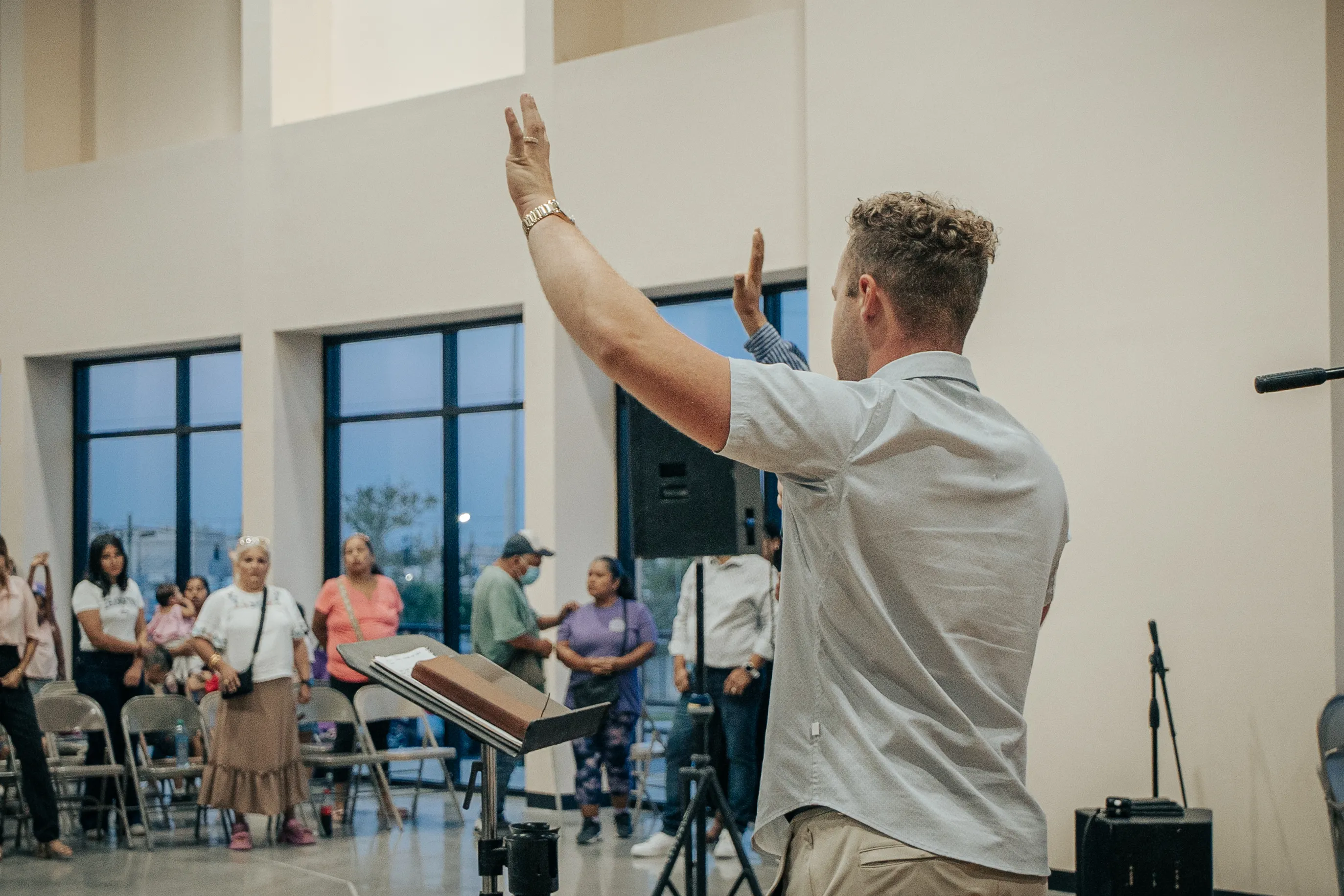 Evangelist Grayson Wilson preaching with his arm extended over a congregation