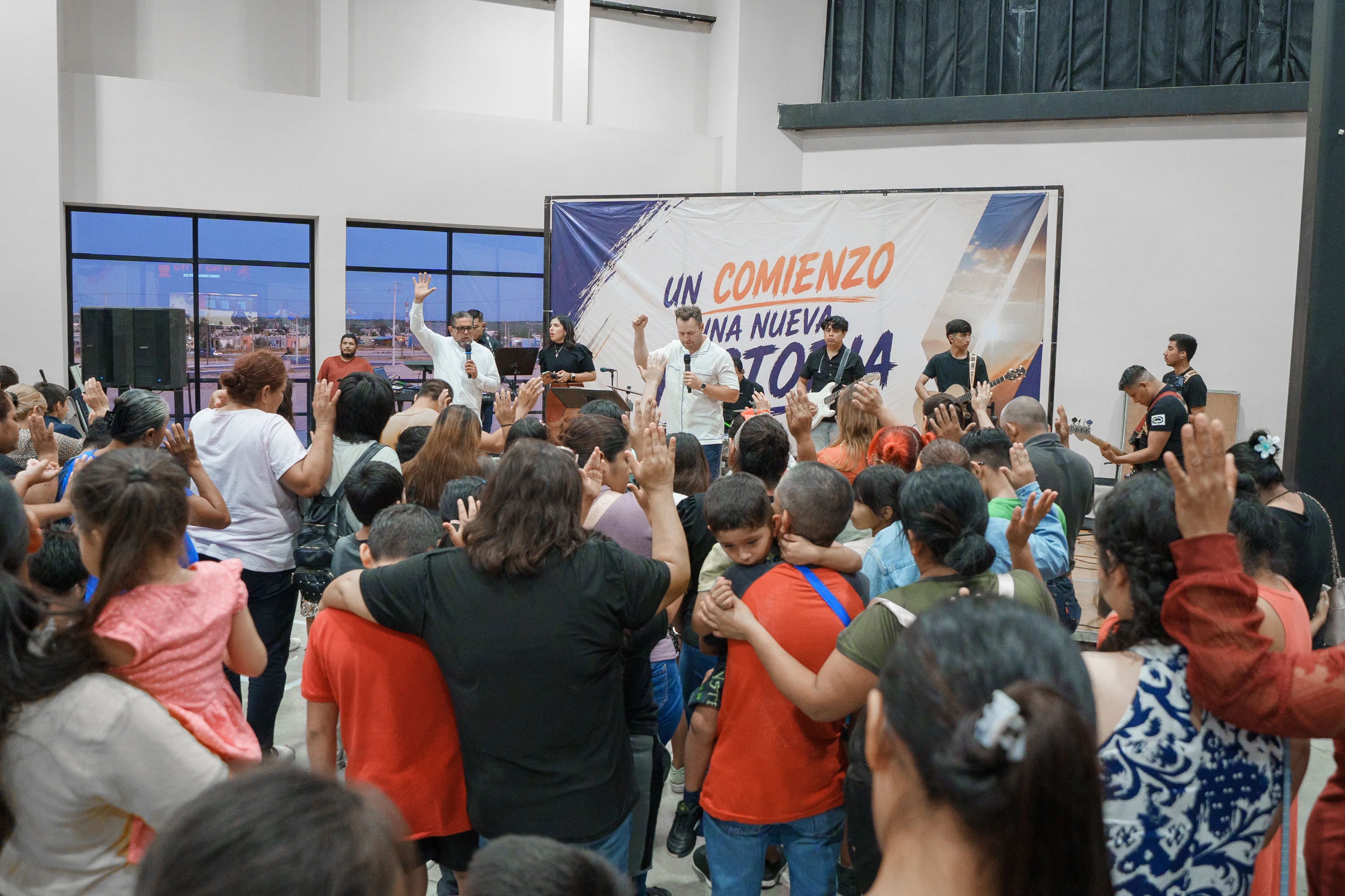 A crowd worshiping in front of the crusade banner