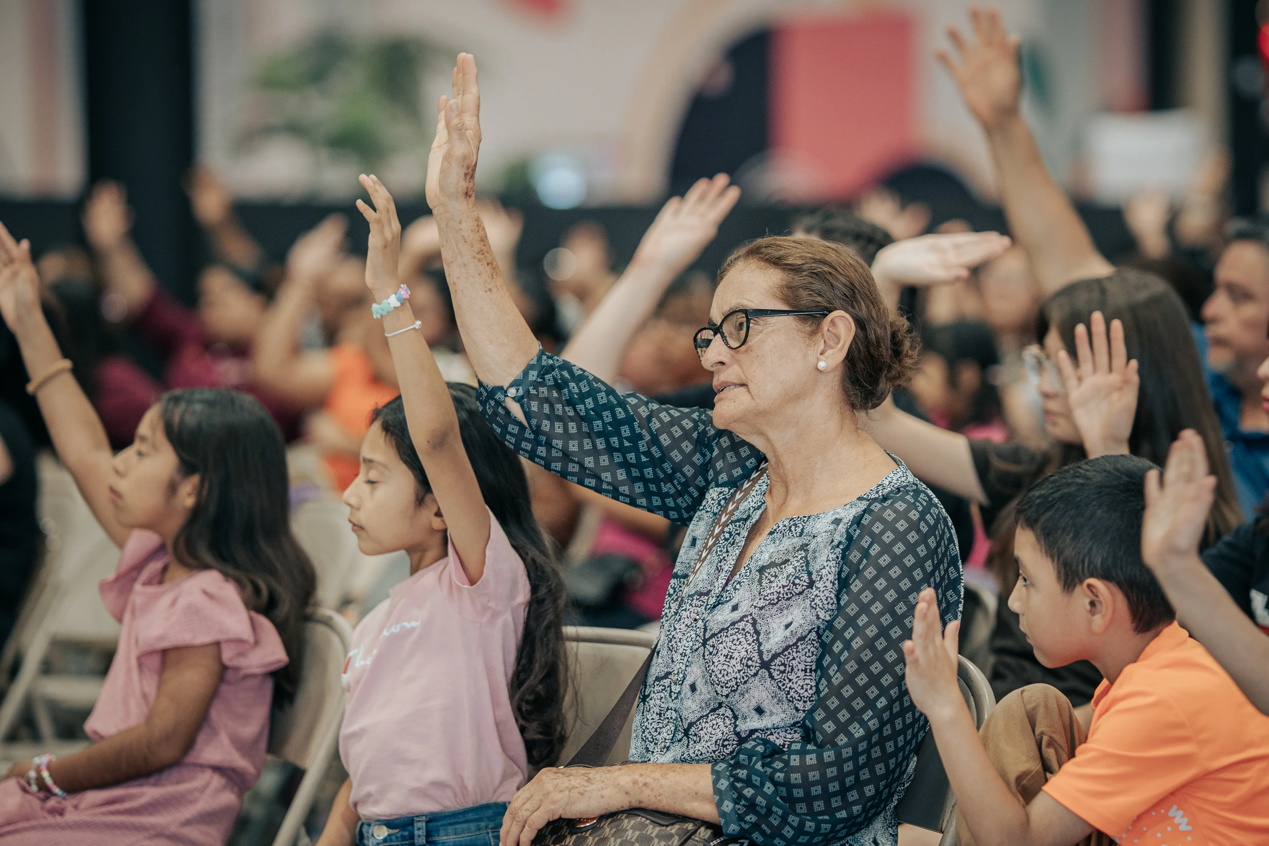 A family worshiping with hands raised