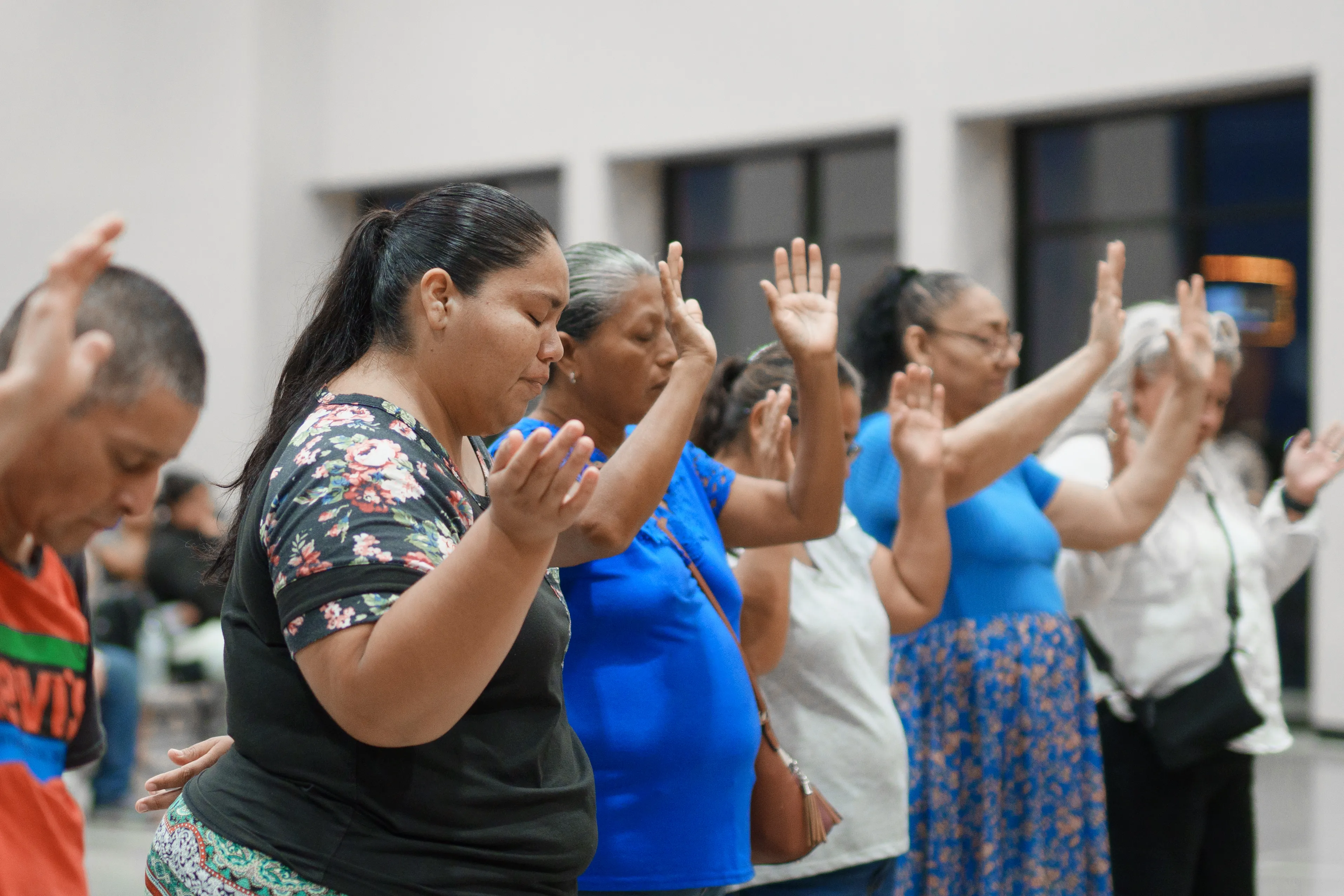 A row of worshipers with hands lifted